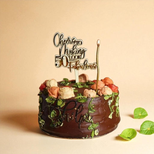 Chocolate cake with floral, forest decorations and a birthday candle on a beige background